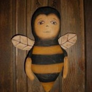 May include: A handmade fabric bee doll with black and yellow stripes, brown wings, and a painted face.