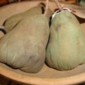 May include: Two green pears with stems sit in a wooden bowl. The pears have a textured surface and are a muted green colour. The bowl is light brown and has a rustic, handcrafted appearance.
