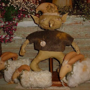 May include: A whimsical handmade gnome doll with a brown felt hat and a brown felt shirt, standing on a wooden base with three white sheep dolls.