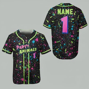 May include: Black baseball jersey with neon green trim and colorful paint splatter design. The front features the text "PARTY ANIMALS" and the number 1. The back has the number 1 and the word "NAME" at the top.