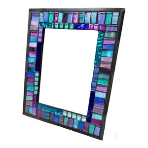 May include: A mosaic picture frame with a black wood frame. The mosaic is made of small, colorful glass tiles in shades of blue, purple, pink, and teal.