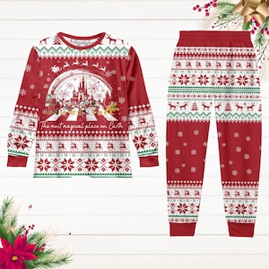 May include: Red and white Christmas pyjamas with a long-sleeved top and trousers. The top features a white graphic of the Disney castle with Mickey Mouse and friends walking across a zebra crossing. The text "The most magical place on Earth" is printed below the graphic. The trousers have a red and white snowflake pattern.