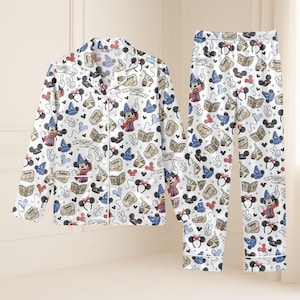 May include: White pajama set featuring a repeating pattern of Mickey Mouse in a sorcerer's hat, Mickey Mouse ears, books, and other Disney-themed graphics. The long-sleeved top has a button-down front and a notched collar. The pants have an elastic waistband.