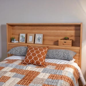 Puede incluir: Cabecero de madera con estante y marcos. La cama tiene un edredón estampado en naranja, gris y blanco. Cojines decorativos con estampados de animales y geométricos completan el look. Ambiente acogedor.