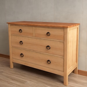 May include: A light wood dresser with four drawers and black metal handles. The dresser has a slightly distressed finish.