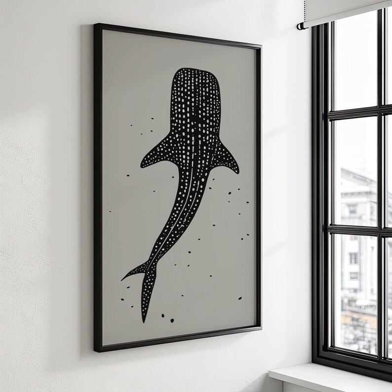 Minimalist illustration print depicting a whale shark swimming in the ocean in an elegant manner, the shark is drawn in a black color with white dots and the background is a beige color with black ink spots, it is hanging in a living room