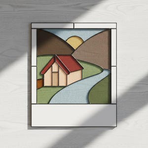 May include: A stained glass panel featuring a landscape scene. The artwork depicts a house with a red roof, a winding blue river, and brown mountains under a yellow sun. The panel is framed in black and white.