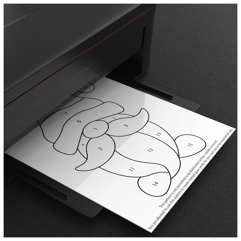 May include: A black and red printer printing a black and white stained glass pattern. The pattern is of a Santa Claus design with numbered sections. Text on the paper states the pattern is for personal or commercial use.