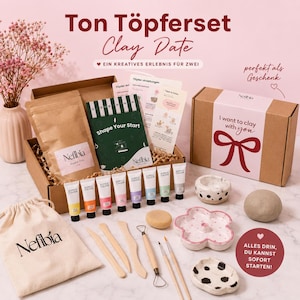 Könnte beinhalten: Ein Töpferset mit einem braunen Karton mit der Aufschrift I want to clay with you, einem beigen Stoffbeutel mit Nefibia-Aufdruck, acht Acrylfarbtuben, Holzmodellierwerkzeugen, einem Schwamm und zwei kleinen Keramikschalen.