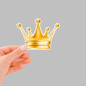 Può includere: Un adesivo a forma di corona dorata con contorno bianco.