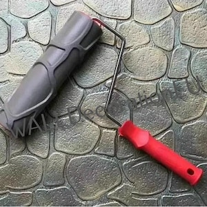May include: A black and red paint roller with a textured pattern resembling stone. The roller is designed to create a faux stone finish on walls.