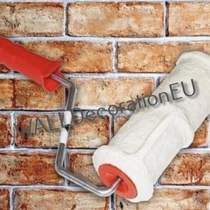 May include: A white textured roller with a red handle is used to create a brick pattern on a wall. The roller is labeled "WALL DecorationEU".
