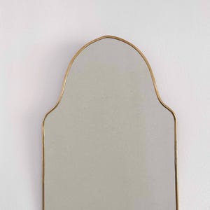 arch brass mirror in white background
