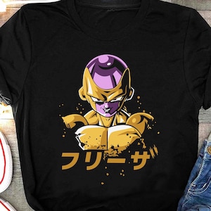 以下が含まれることがあります： ドラゴンボールZの金色フリーザのキャラクターのグラフィックがプリントされた黒いTシャツ。Tシャツには日本語で「フリーズ」とプリントされています。