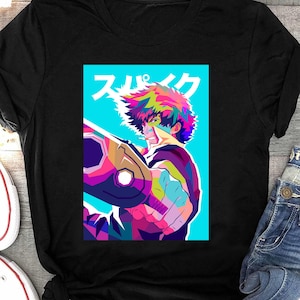 Puede incluir: Una camiseta negra con una ilustración de arte pop colorida de un personaje del anime Cowboy Bebop. El personaje sostiene una pistola y el texto japonés "ス  パ  イ  ク" está en el fondo.