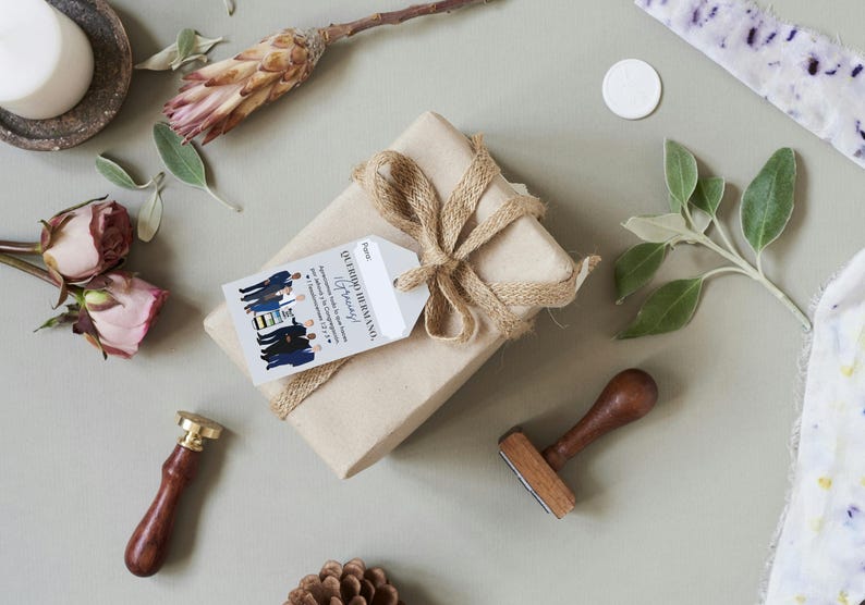 May include: A brown gift box wrapped with twine and a gift tag that reads "Our Wedding Ceremony" and "To our family". The gift tag is decorated with a group of people in blue suits and a yellow and black pattern.