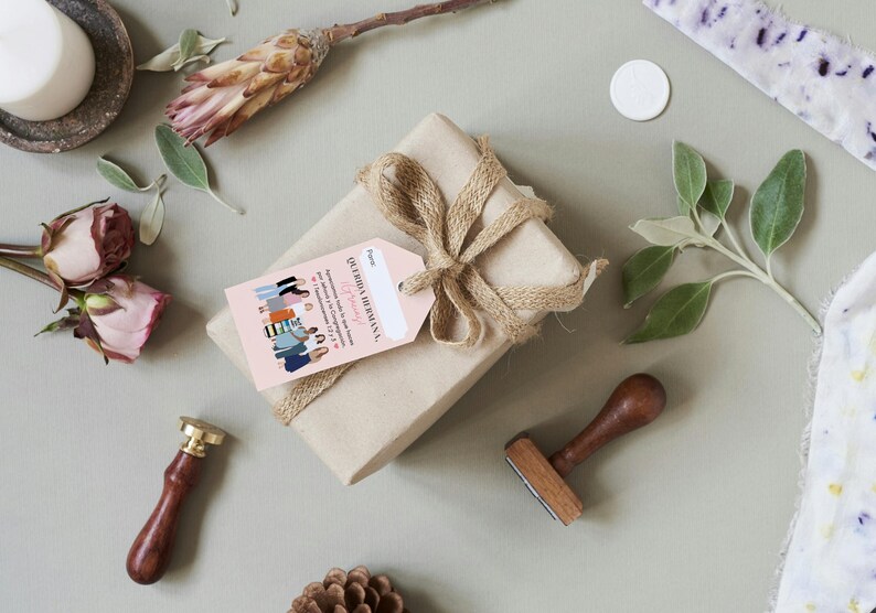 May include: A brown gift box wrapped with twine and a pink gift tag that reads "Our Family is Growing" with a line drawing of a group of women.