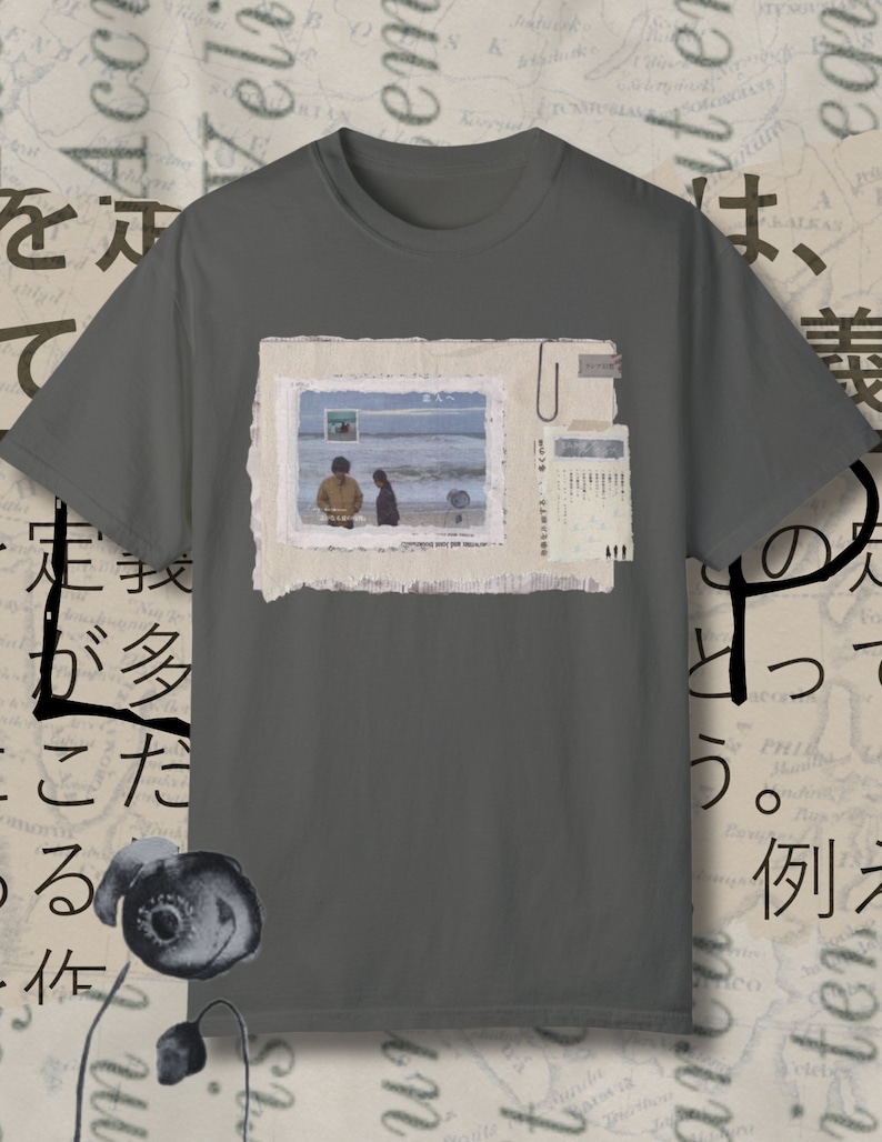 May include: A gray t-shirt with a vintage-style photo of two people walking on a beach. The photo is surrounded by a white border and has a paper texture. The text "Somewhere over the rainbow" is printed below the photo.