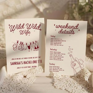 May include: Two cream-colored bachelorette party invitation cards with dark red text and graphics. The left card reads Wild Wild Wife and features a clothesline with boots and swimwear. The right card lists weekend details with a champagne bottle.