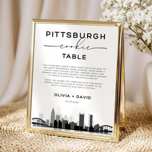Peut inclure: Un panneau doré avec l'inscription "Pittsburgh Cookie Table" en écriture élégante. Le panneau comprend un texte sur la tradition et un graphique de l'horizon de Pittsburgh. Les noms "Olivia + David" et la date sont également affichés.