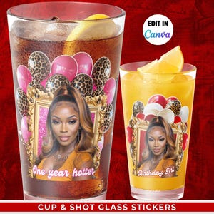 May include: Two clear glasses, one tall and one short, each with a decorative sticker. The stickers feature a woman's portrait, pink balloons, and leopard print balloons. The tall glass says "One year hotter," and the short glass says "Birthday Girl."