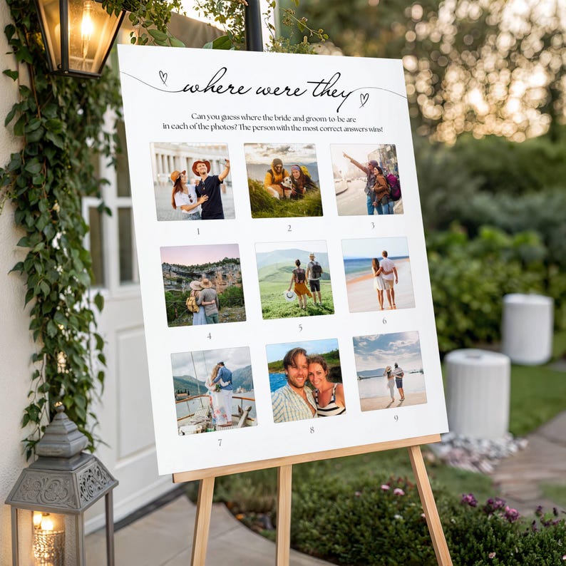 May include: A white sign on a wooden easel with the text "where were they" and nine framed photos. The sign is for a wedding game, inviting guests to guess the locations in the photos. The sign is outdoors.