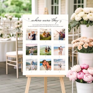 May include: A white sign on a wooden easel with the text "where were they". The sign features nine small photos and the text "Can you guess where the bride and groom to be are in each of the photos? The person with the most correct answers wins!"