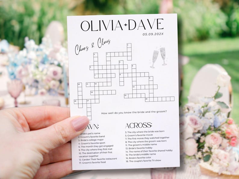 K&ouml;nnte beinhalten: Eine wei&szlig;e Karte mit einem Kreuzwortr&auml;tsel mit dem Titel "Cheers & Clues" f&uuml;r die Hochzeit von Olivia und Dave. Das Datum 05.09.202X wird angezeigt. Die Karte enth&auml;lt ein Kreuzwortr&auml;tsel und Hinweise, mit zwei Champagnergl&auml;sern oben.