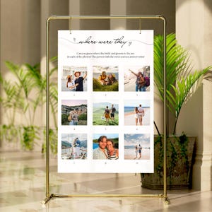 May include: A gold metal frame holds a white sign with the text "where were they". The sign has nine small photos. The text asks guests to guess where the bride and groom were in each photo.