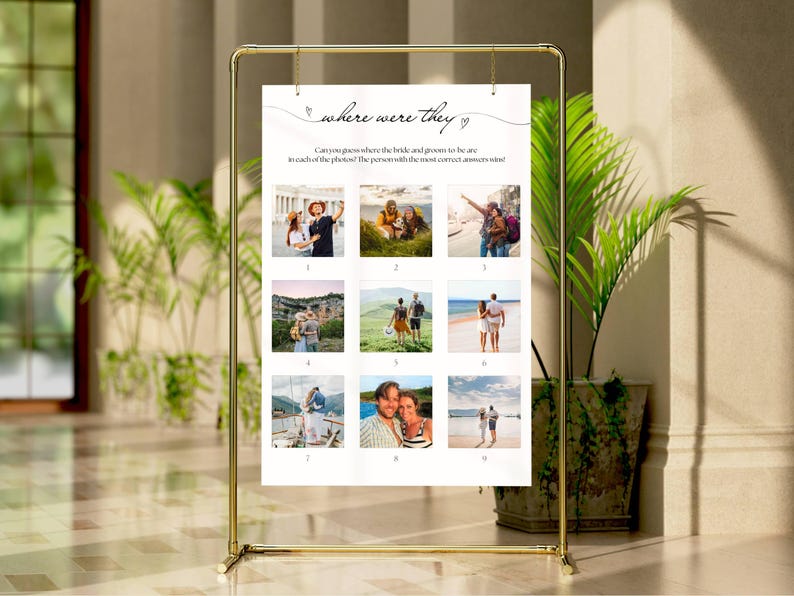 May include: A gold metal frame holds a white sign with the text "where were they". The sign has nine small photos. The text asks guests to guess where the bride and groom were in each photo.