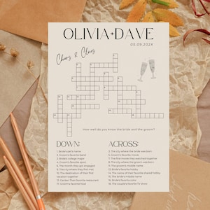 K&ouml;nnte beinhalten: Ein cremefarbenes Hochzeitskreuzwortr&auml;tsel mit den Namen "OLIVIA + DAVE" und dem Datum "05.09.202X" oben. Das R&auml;tsel enth&auml;lt Hinweise und eine Champagnerglas-Illustration. Das Thema sind Hochzeitsspiele.