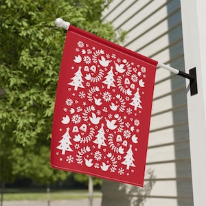 May include: A red Christmas flag with a white Scandinavian-style pattern of trees, birds, snowflakes, and hearts.