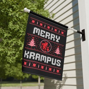 May include: Black flag with the words "MERRY KRAMPUS" in white, with a red Krampus illustration and Christmas tree designs. The flag is hanging outside on a white wall.