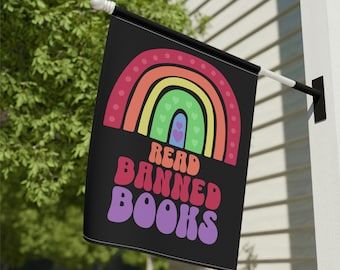 Könnte beinhalten: Eine schwarze Flagge mit einem Regenbogen und dem Text "Read Banned Books" in bunter Retro-Schrift.