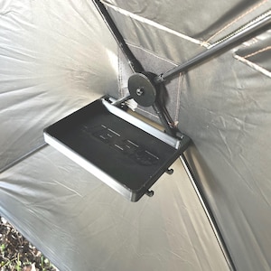 May include: A black plastic tray with the word "JEBCO" printed on it is attached to the inside of a gray tent.