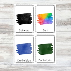 May include: Four flashcards with different colored swatches and German words for the colors. The colors are black, rainbow, dark blue, and dark green. The words are "Schwarz", "Bunt", "Dunkelblau", and "Dunkelgr&uuml;n".