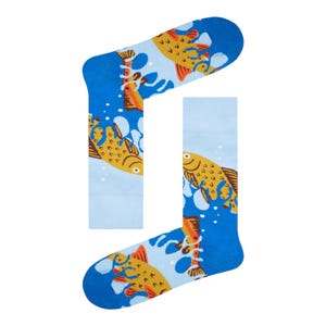 May include: A pair of blue socks featuring a repeating pattern of yellow fish and white water splashes. The socks have a light blue background with darker blue accents at the top and bottom.