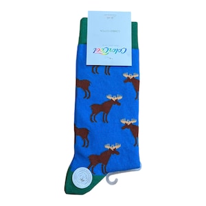 May include: A pair of blue socks with a green cuff and a white cotton label. The socks feature a repeating pattern of brown moose on a blue background. The label reads "ColorCool" and "Combed Cotton".