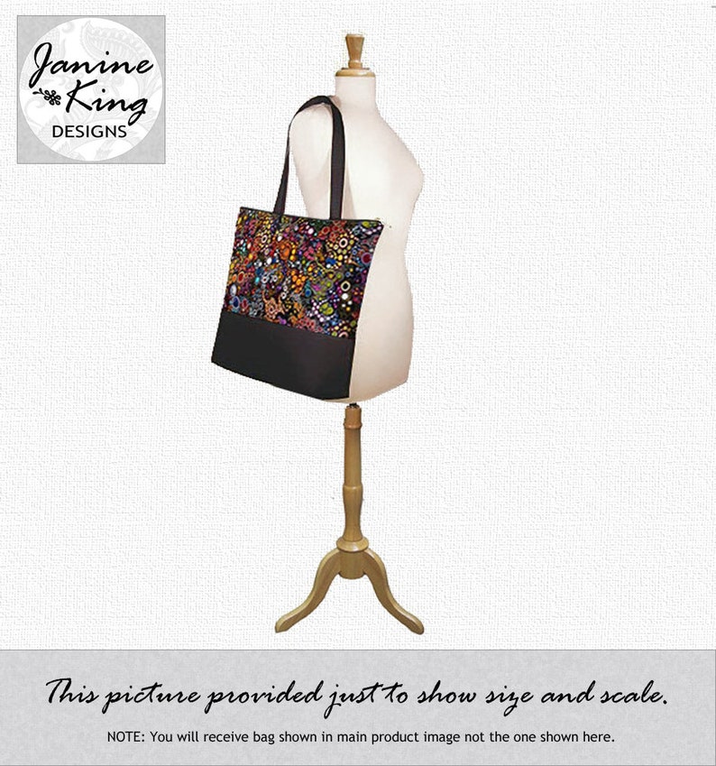 Puede incluir: Una bolsa tote negra con un estampado floral colorido y cierre de cremallera. La bolsa est&aacute; en un maniqu&iacute; de madera. "Esta imagen se proporciona solo para mostrar el tama&ntilde;o y la escala. AVISO: Recibir&aacute; la bolsa que se muestra en la imagen principal del producto, no la que se muestra aqu&iacute;."