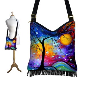May include: A colorful abstract painting of a tree with a large yellow moon in the background. The painting is printed on a black canvas tote bag with a fringe trim.