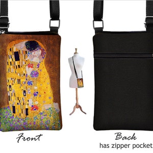 May include: A black canvas crossbody bag with a zipper pocket on the back. The front of the bag features a colorful print of Gustav Klimt's "The Kiss" painting.