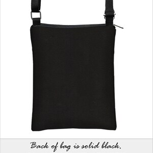 May include: Black crossbody bag with a black adjustable strap and a zipper closure. The bag is made of twill upholstery fabric and is water and stain resistant. The back of the bag is solid black.