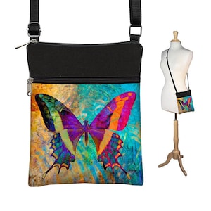 May include: A black crossbody bag with a zippered pocket and a colorful butterfly design on the front. The butterfly has a blue, green, yellow, orange, and purple color scheme.