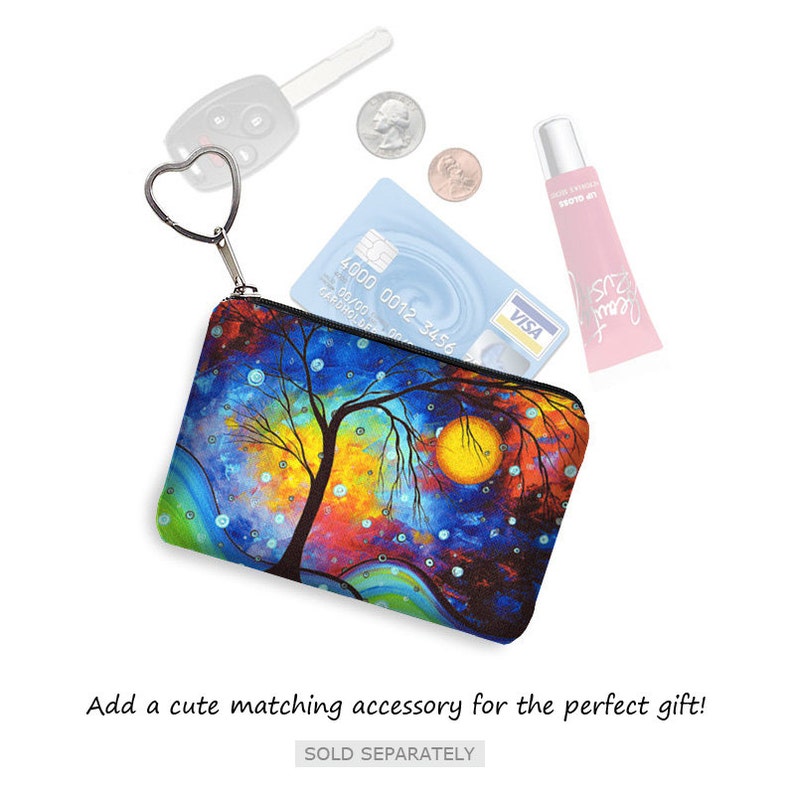 May include: A colorful zippered pouch with a whimsical painting of a tree and a moon. The pouch has a heart-shaped zipper pull and is perfect for holding small items like cash, cards, and keys.