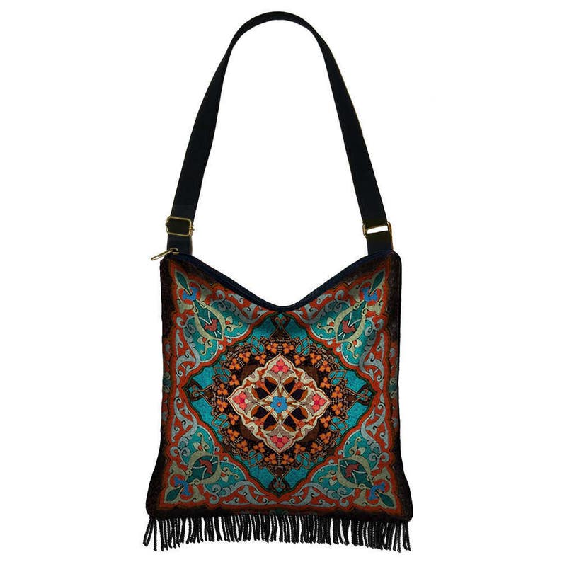 May include: A blue, orange, and green patterned shoulder bag with a fringe trim. The bag has a black strap and a gold buckle.