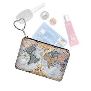 May include: A small zippered pouch with a world map print. The pouch has a heart-shaped zipper pull and is filled with various items, including a credit card, lip gloss, and keys.