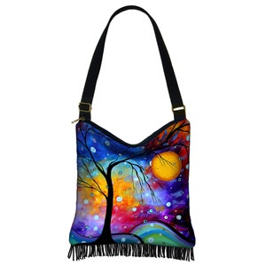 May include: A colorful canvas tote bag with a fringe trim. The bag features a painting of a tree with a large yellow sun in the background. The colors in the painting are blue, purple, orange, yellow, and green.