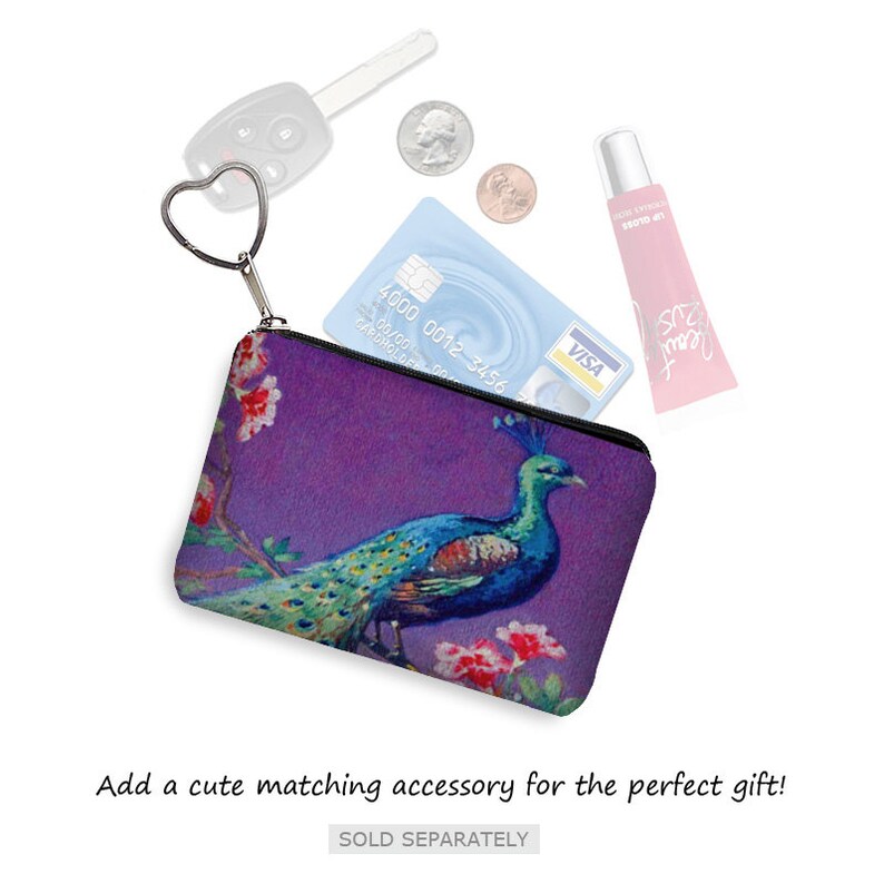 Pode incluir: Uma pequena bolsa roxa com z&iacute;per e um design de pav&atilde;o. A bolsa est&aacute; aberta e cont&eacute;m um cart&atilde;o de cr&eacute;dito, uma chave e um tubo de brilho labial.