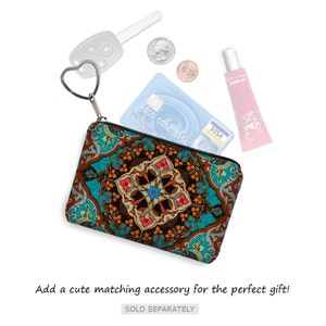 May include: A small, teal zippered pouch with a colorful, intricate geometric pattern. The pouch is open and has a credit card, a key, and a tube of lip gloss inside.