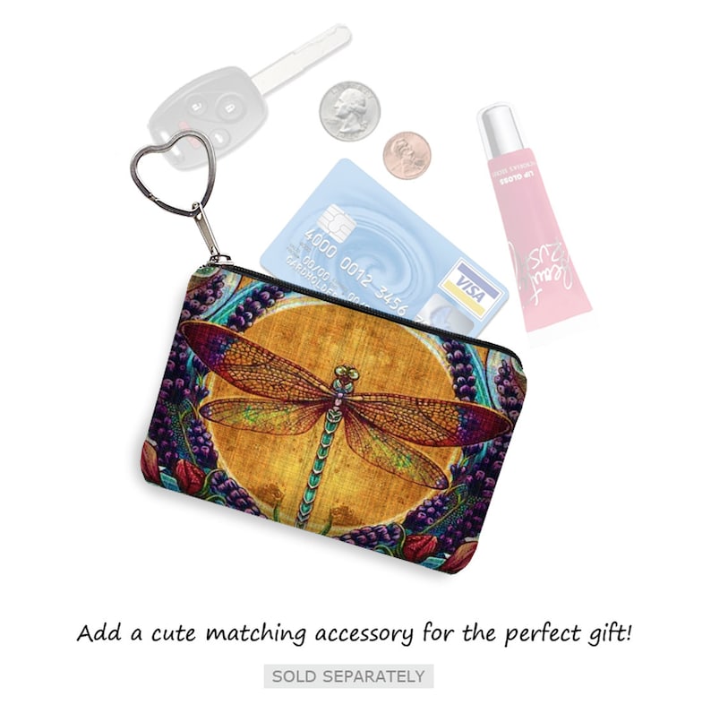 May include: A small zippered pouch with a dragonfly design. The pouch is made of fabric and has a zipper closure. The dragonfly is colorful and has a yellow background. The pouch is surrounded by other items, including a credit card, a key, and a tube of lip gloss.